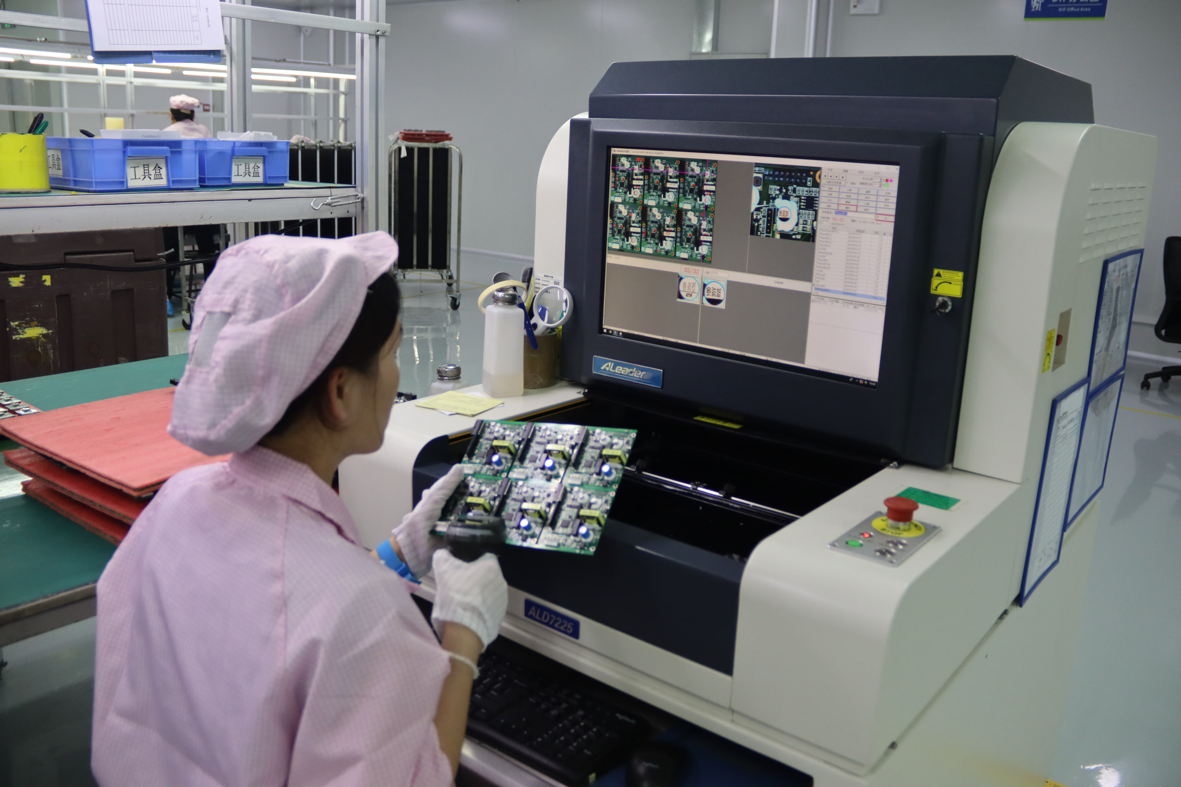 KeepBest operator reviewing an assembled circuit board at an optical inspection station
